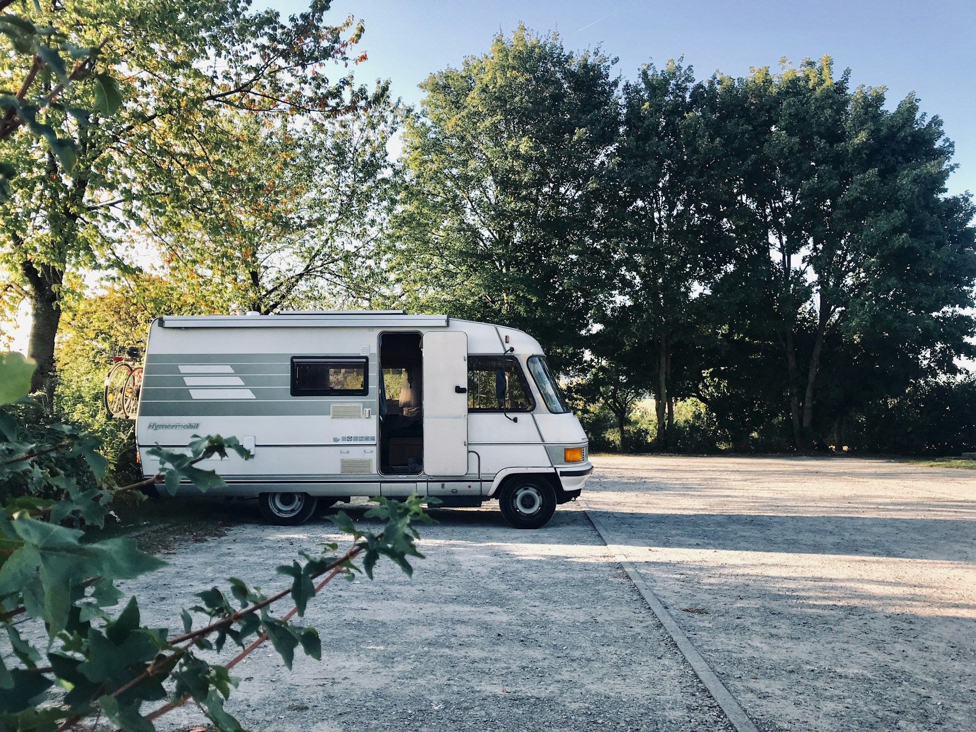 Witte klassieke Hymermobil camper langs een landweg